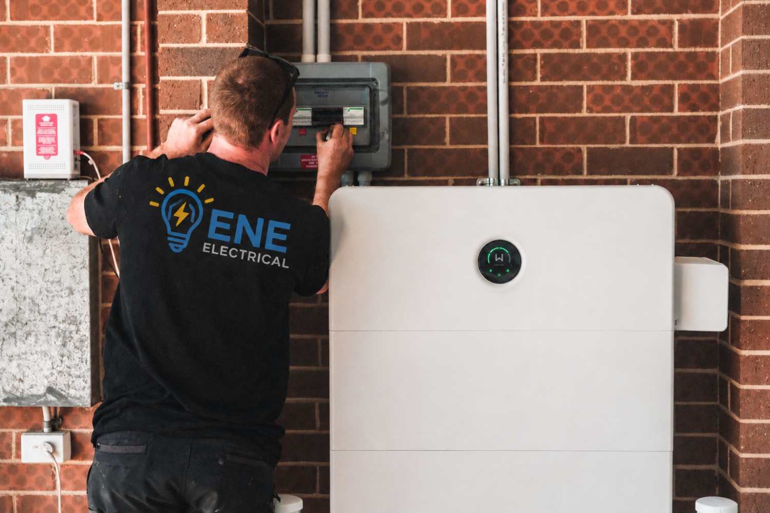 Licensed electrician installing smart-enabled security lighting for a residential home